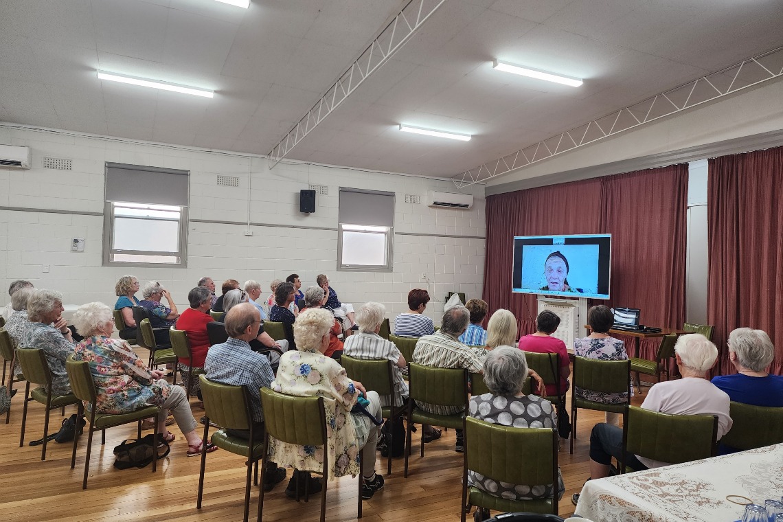 Group of supporters watching watching Valerie Browning on screen