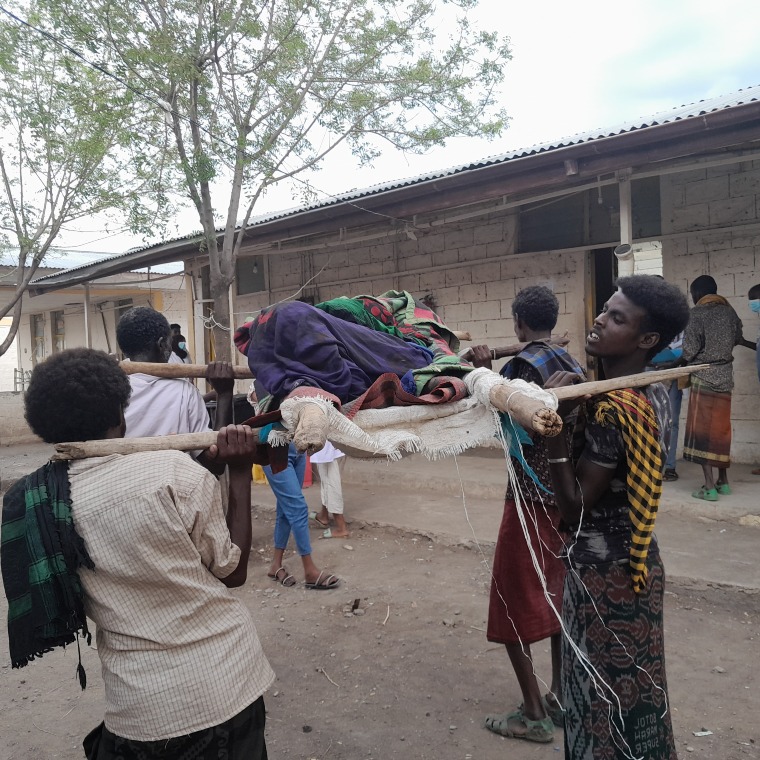 Woman being carried on a hand-held traditional stretcher